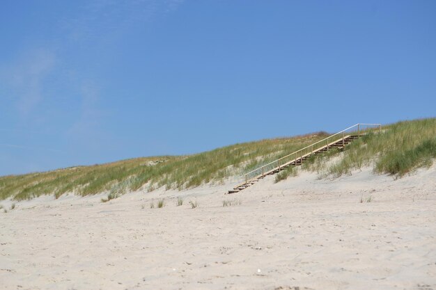 Foto schilderachtig uitzicht op zand op het strand tegen een heldere blauwe lucht tijdens een zonnige dag
