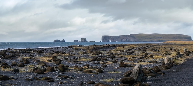 Foto schilderachtige herfst dyrholaey kaap en rotsformaties uitzicht vanaf reynisfjara oceaan zwart vulkanisch zandstrand vik zuid-ijsland