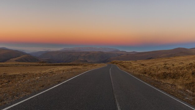 Foto schilderachtige weg in de bergen bij zonsondergang