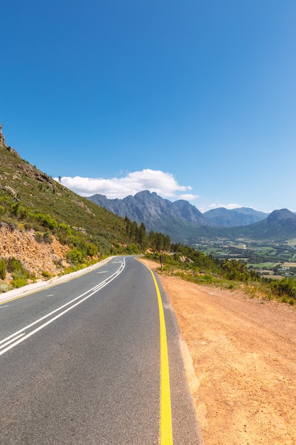 Schilderachtige weg in Franschhoek vallei met zijn beroemde wijnmakerijen en omliggende bergen, Zuid-Afrika