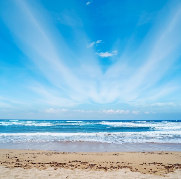 Schilderachtige wolken boven een strand van Sardinië