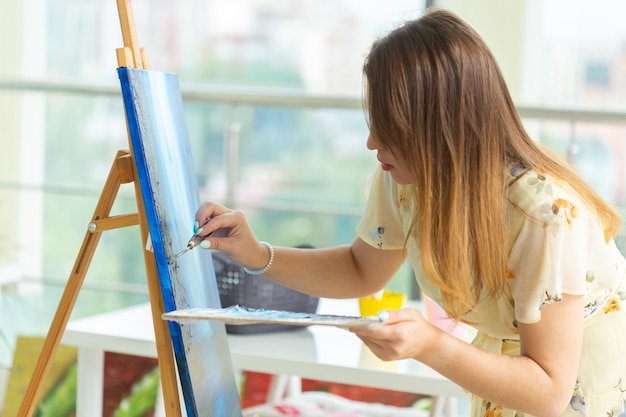 Schilderkunst lessen. cursussen tekenen. vaardigheden verbeelding en inspiratie. Close-up van charmant studentenmeisje die beeld op schildersezel creëren.