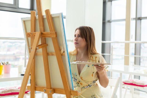 Schilderkunst lessen. tekencursussen. vaardigheden verbeelding en inspiratie. Charmant studentenmeisje dat beeld op ezel maakt.