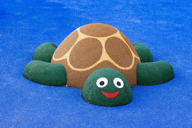 Schildpad gemaakt van vilt op een blauwe achtergrond, close-up van de foto