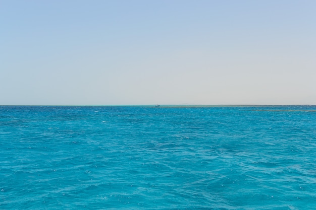 Schip aan de horizon van de blauwe zee