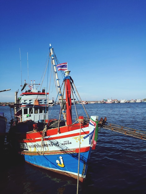 Schip aan wal op zee tegen een heldere blauwe lucht