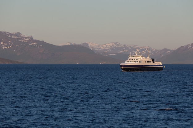 Schip om fjorden in Noorwegen te bezoeken. Een mystieke fjord met donkere wolken in Noorwegen met bergen en mist die boven het water hangen