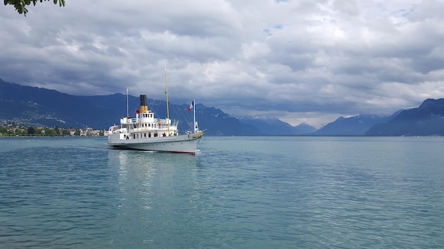 Schip zeilt op zee tegen bewolkte lucht
