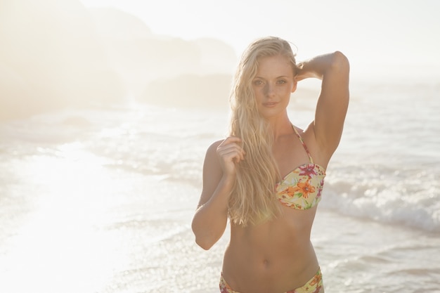 Schitterend blonde in het bloemenbikini stellen bij het strand