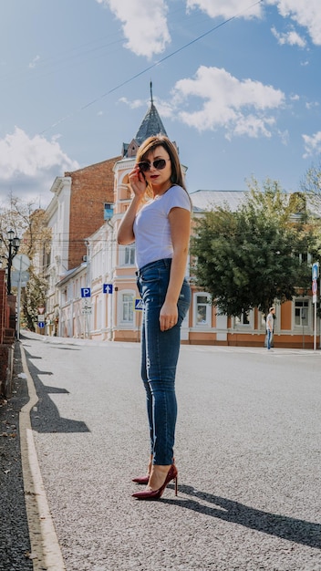 Schitterend jong vrouwenmodel dat camera bekijkt die zich in de stad stelt