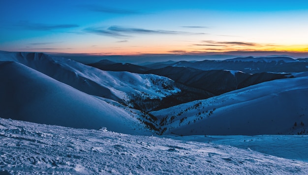 Schitterend mooi uitzicht op de pistes in het skigebied na zonsondergang in de late avond.