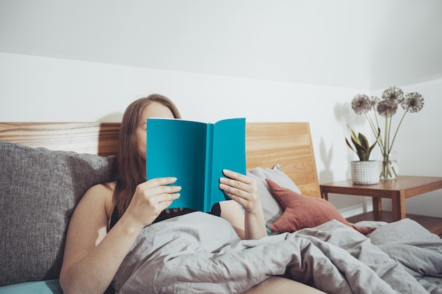 Schitterende jonge vrouw die ochtend selfie in bed neemt