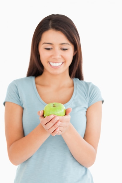 Schitterende vrouw die een groene appel houdt