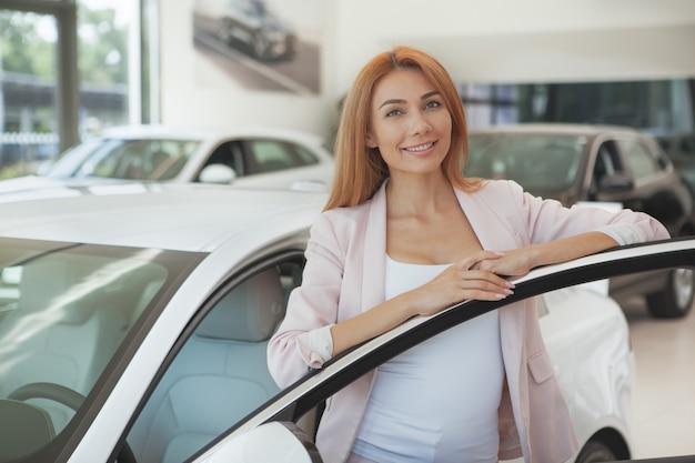 Schitterende vrouw die een nieuwe auto kiest bij het handel drijven