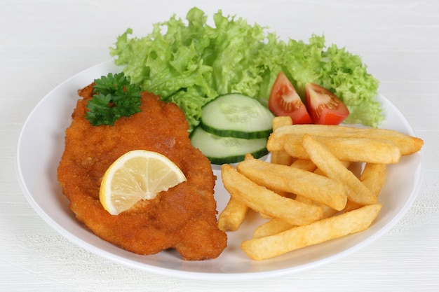 Schnitzel meal with french fries salad and lemon