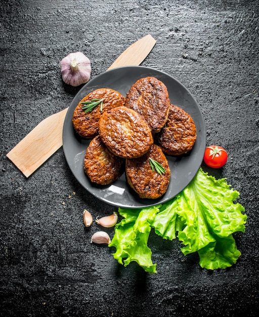 Schnitzels op een bord met knoflooksalade en houten spatel