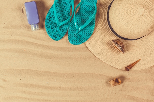 Schoenen en hoed op het strand