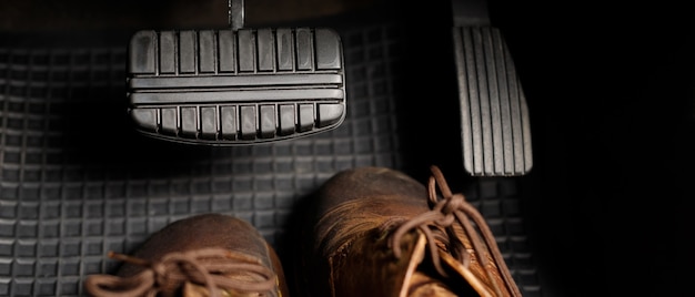 Schoenen onder de remmen van de auto veroorzaken gevaar en ongevallen voor de bestuurder.