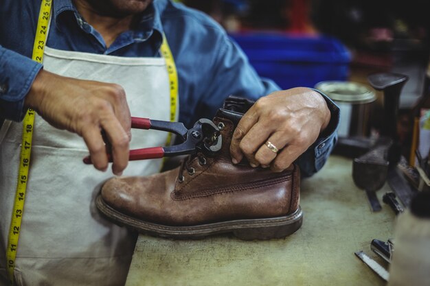 Foto schoenmaker die een schoen herstelt