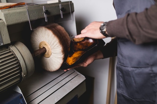 Schoenmaker in werkplaats polijsten nieuwe handgemaakte mooie leren schoenen.