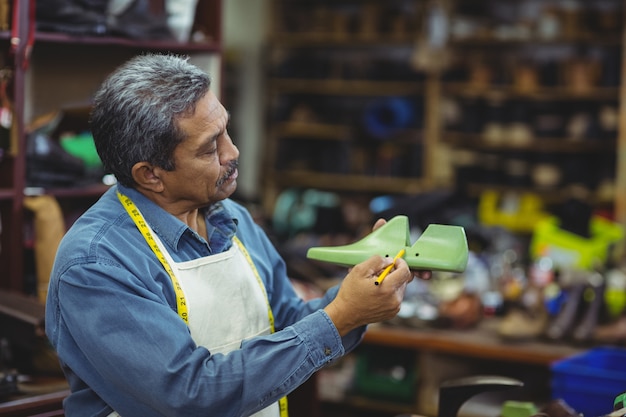 Schoenmaker markering op schoen leest met pen