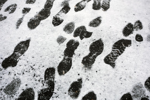 Schoensporen op het besneeuwde asfalt