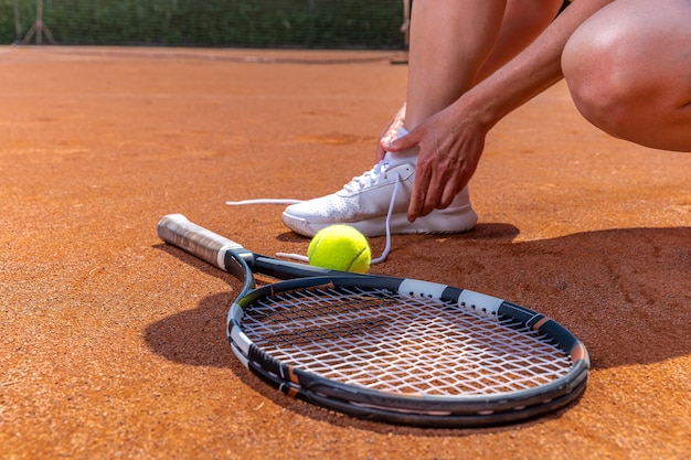 Schoenveter tennisschoenen binden op de baan, racket en bal.