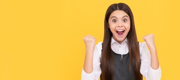 Scholarship winner happy teenage winner yellow background girl child give winning gesture child face horizontal poster teenager girl isolated portrait banner with copy space