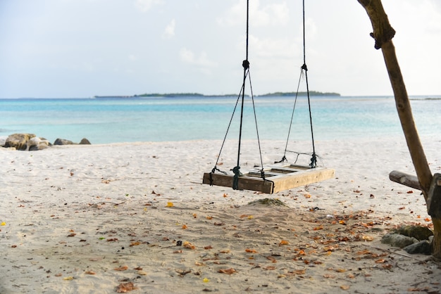 Schommeling het hangen onder de boom op strand in de Maldiven