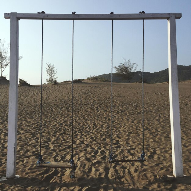 Foto schommelt over het zand tegen een heldere lucht