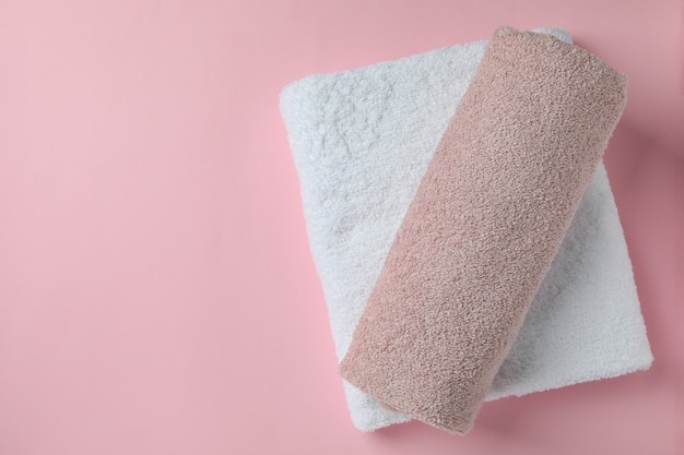 Foto schone gevouwen handdoeken op roze achtergrond, ruimte voor tekst