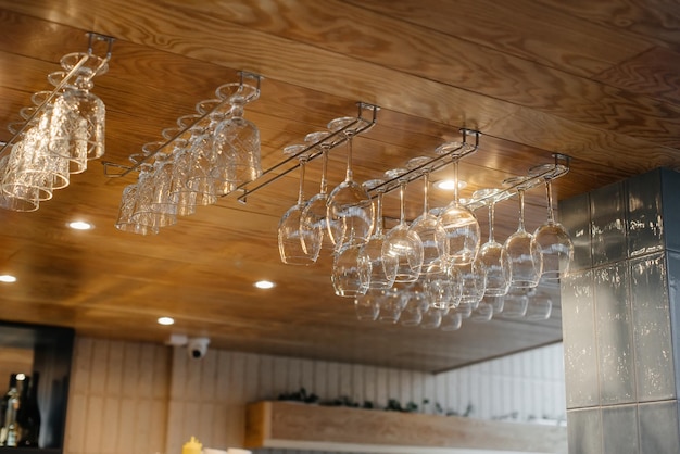 Schone glazen voor alcoholische dranken hangen boven de bar in een modern restaurant.