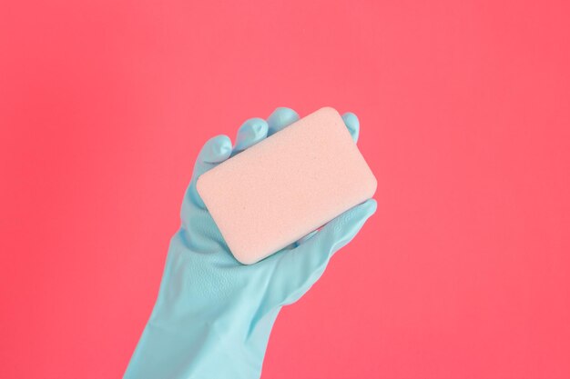 Schoner concept hand in rubberen handschoenen en zeep vasthouden voor het schoonmaken geïsoleerd op roze achtergrond