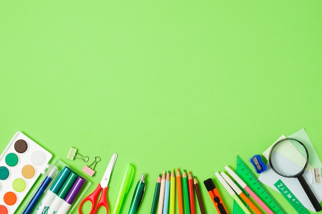 School accessories arrangement on green background