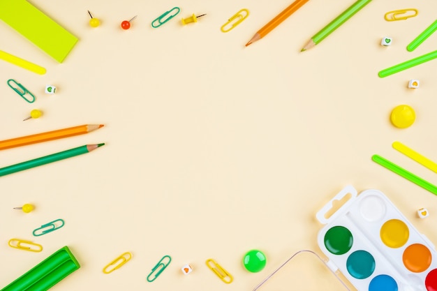 School accessories on a yellow table. Pastel colored.