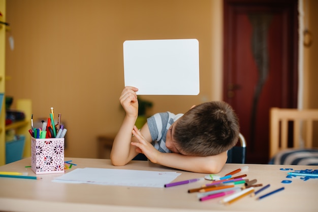 A school-age boy does homework at home. Training at school