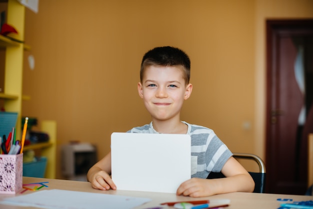 A school-age boy does homework at home. Training at school