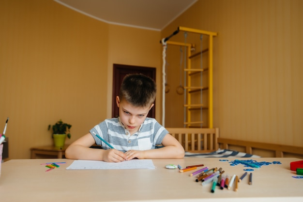 A school-age boy does homework at home. Training at school.