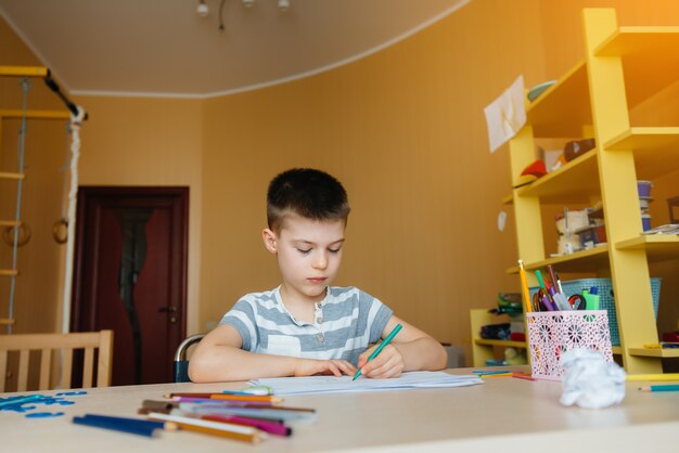 A school-age boy does homework at home