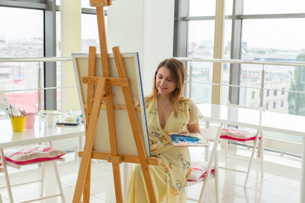 School of art, college of arts, education for group of young students. Happy young woman smiling, girl learning to paint.