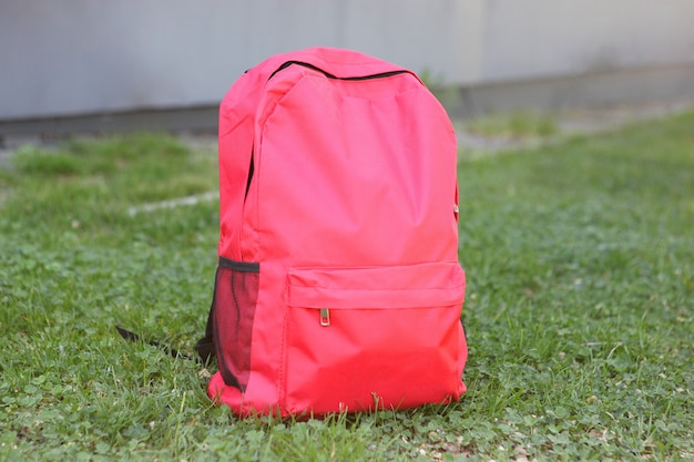 School backpack on the grass outside closeup