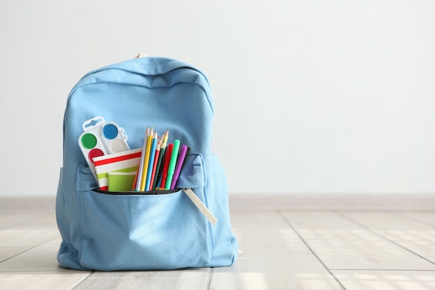 School backpack and stationery in a bright room