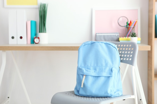 School backpack and stationery in a bright room