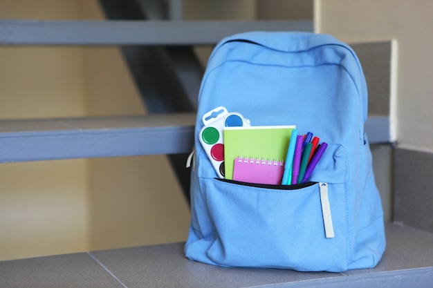 School backpack and stationery in a bright room