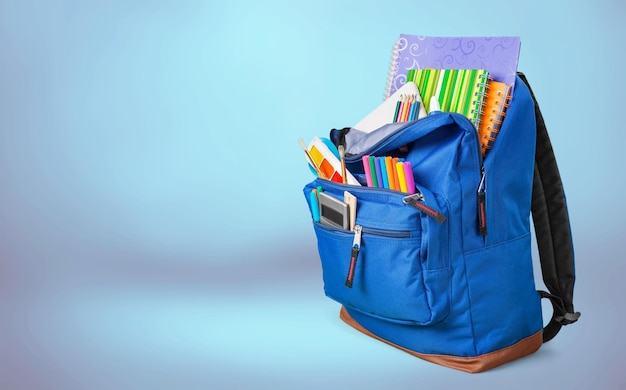 School Backpack with stationery on background