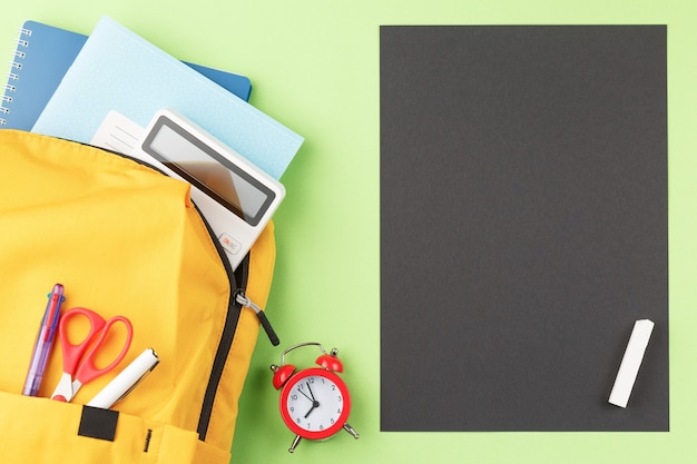 School board with backpack and study supplies