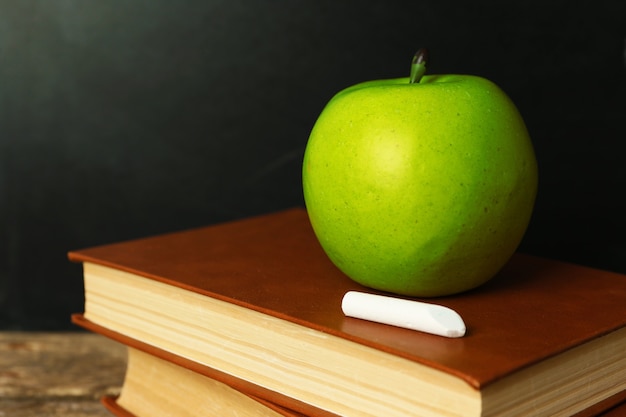 School books on desk near chalkboard