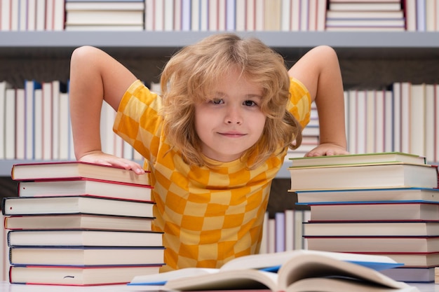 本屋や学校図書館の子供の勉強で本を読んでいる学校の男の子の子供の生徒が読んだ