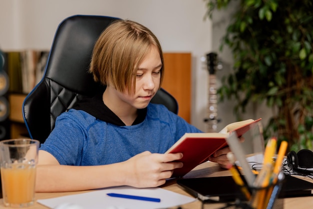 A school boy is reading a book in room