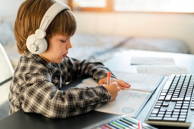 school boy taking online courses side view